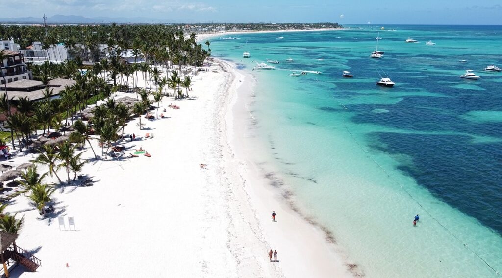 Aerial view of white-sand Bavaro Beach with turquoise water and anchored boats in Punta Cana