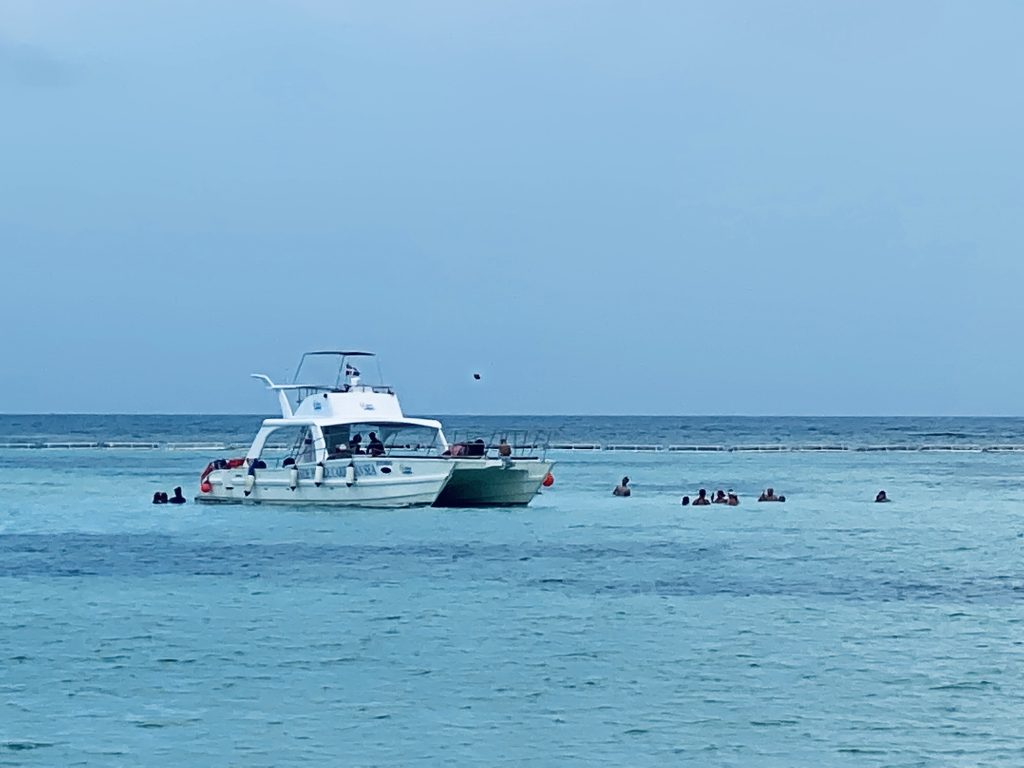 Boats and snorkelers at dusk off the coast of La Romana