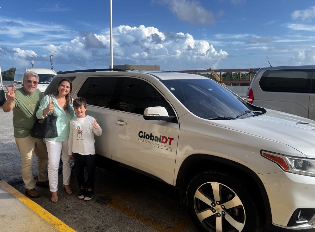 Family next to a white Chevrolet Traverse on a GlobalDT airport transfer
