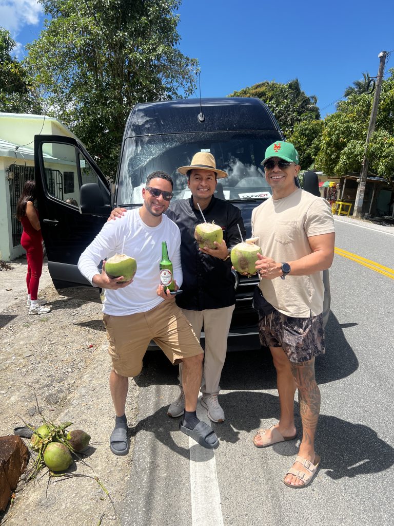 Travelers enjoying fresh coconuts during a GlobalDT transfer stop in Punta Cana