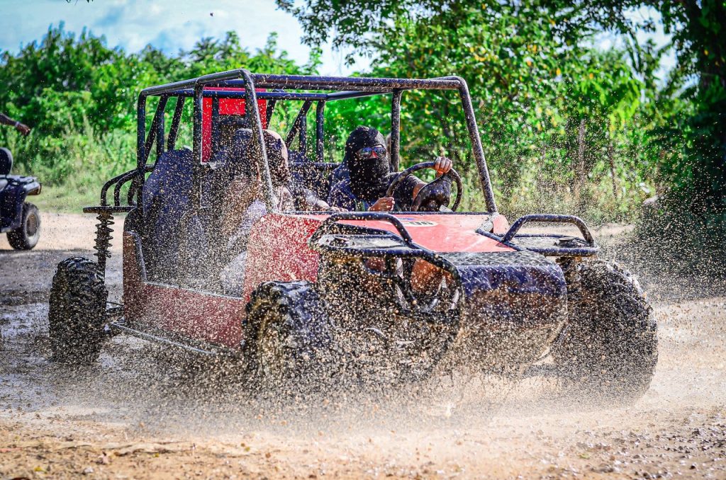 Off-road dune buggy splashing through mud near Punta Cana